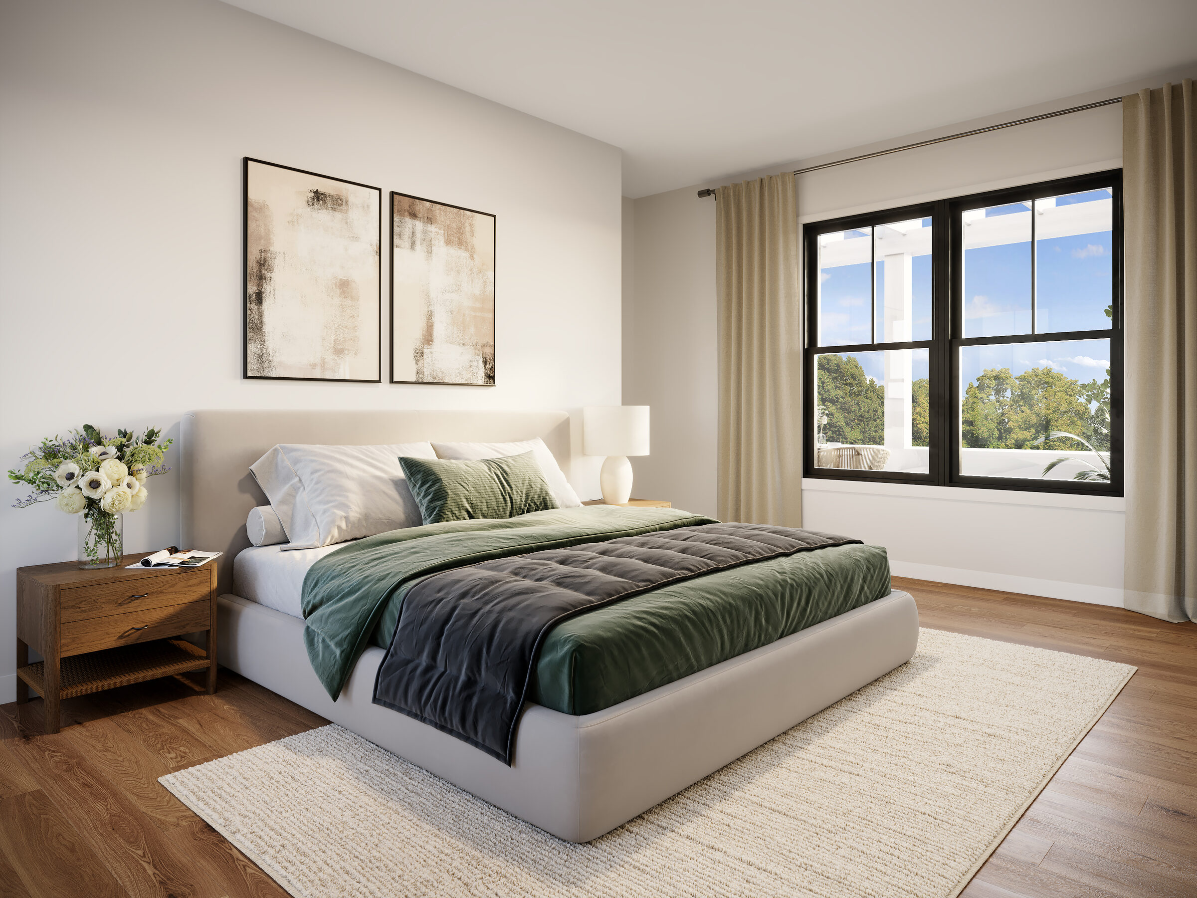 Bedroom with upholstered bed, large window with natural light, wood floors, and nightstand with floral arrangement